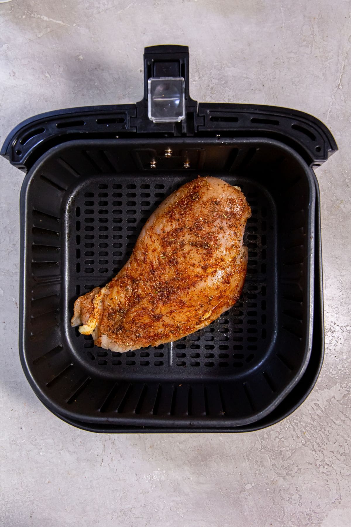 Black Air Fryer with raw chicken inside