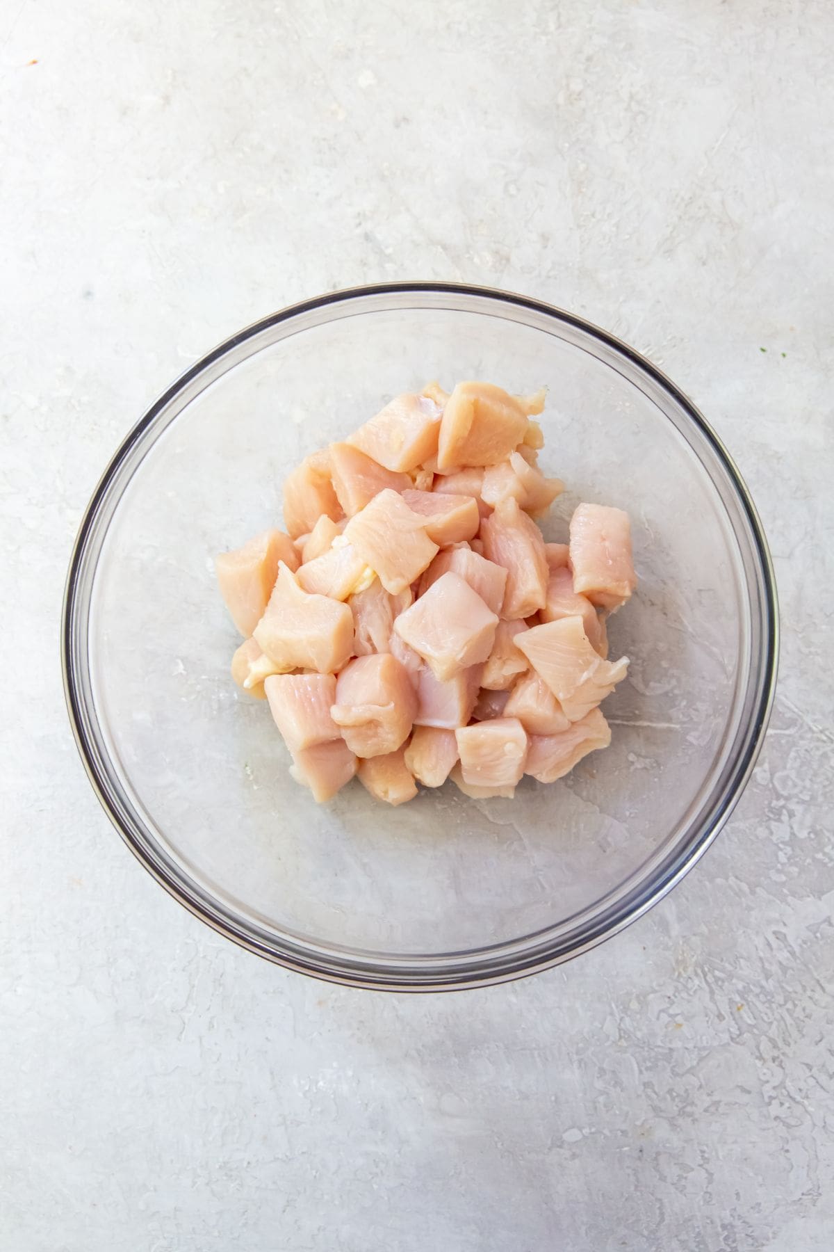 Glass bowl with cubed chicken in it