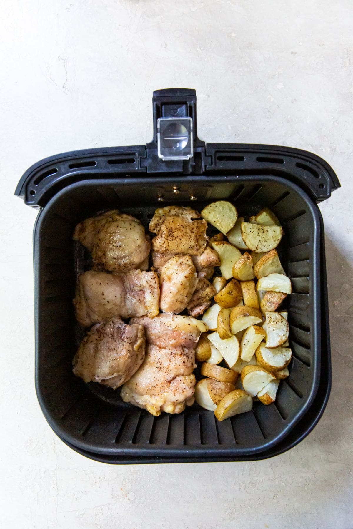 cooked chicken thighs and potatoes in a Air Fryer.