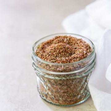 Mason jar with dry rub seasoning inside. White towel on the side