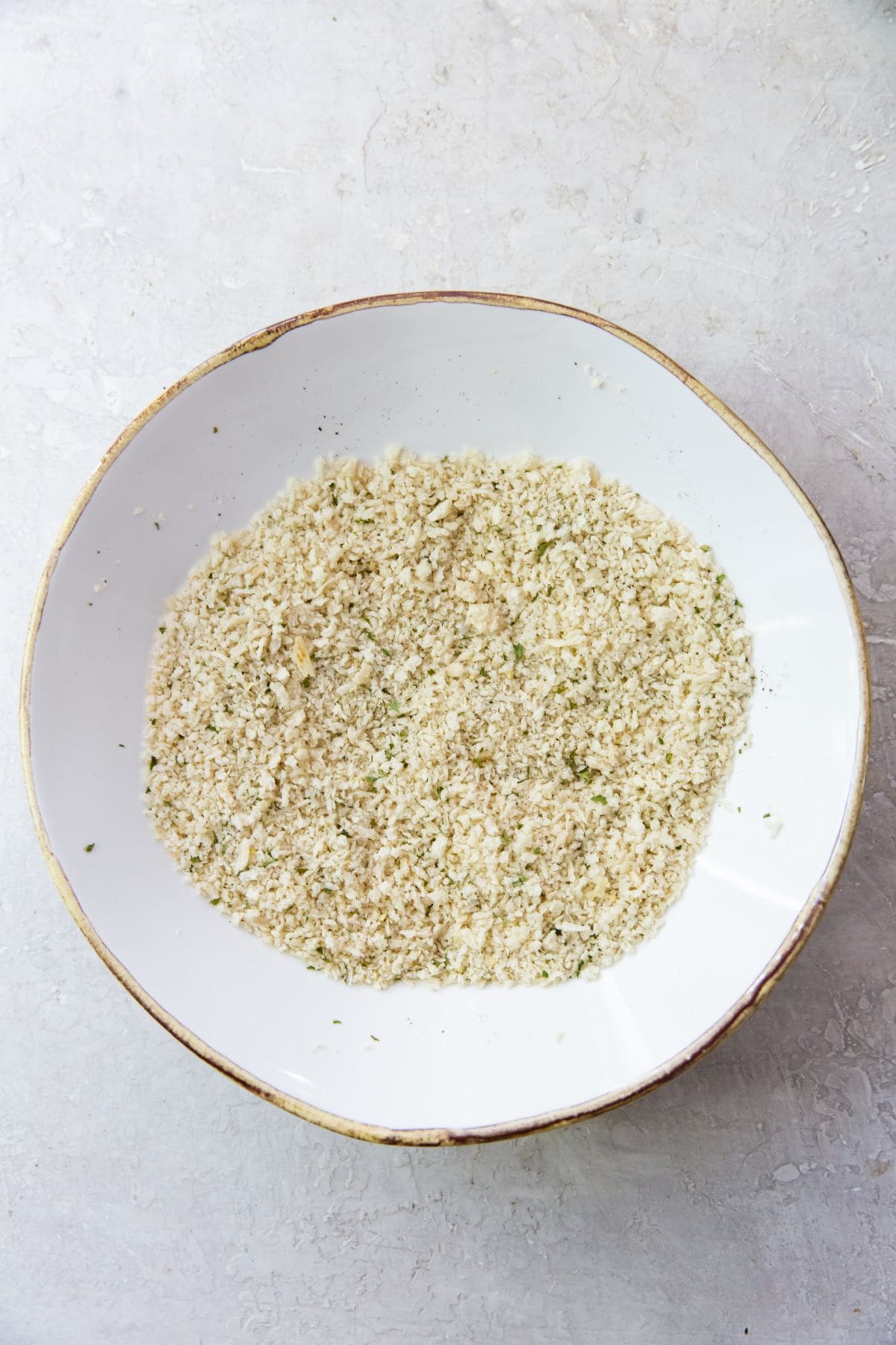 white bowl with bread crumbs and seasoning mixed together