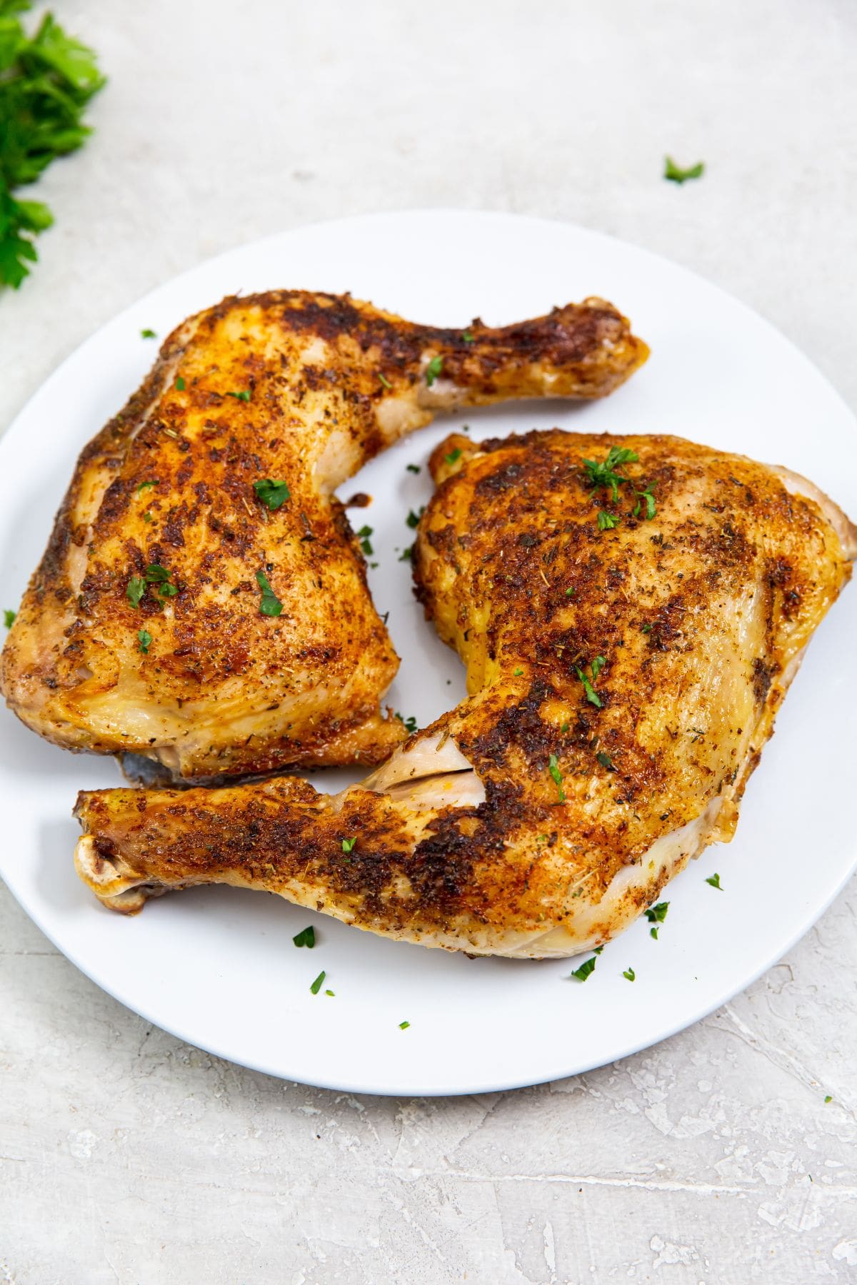 white plate with chicken in the back parsley