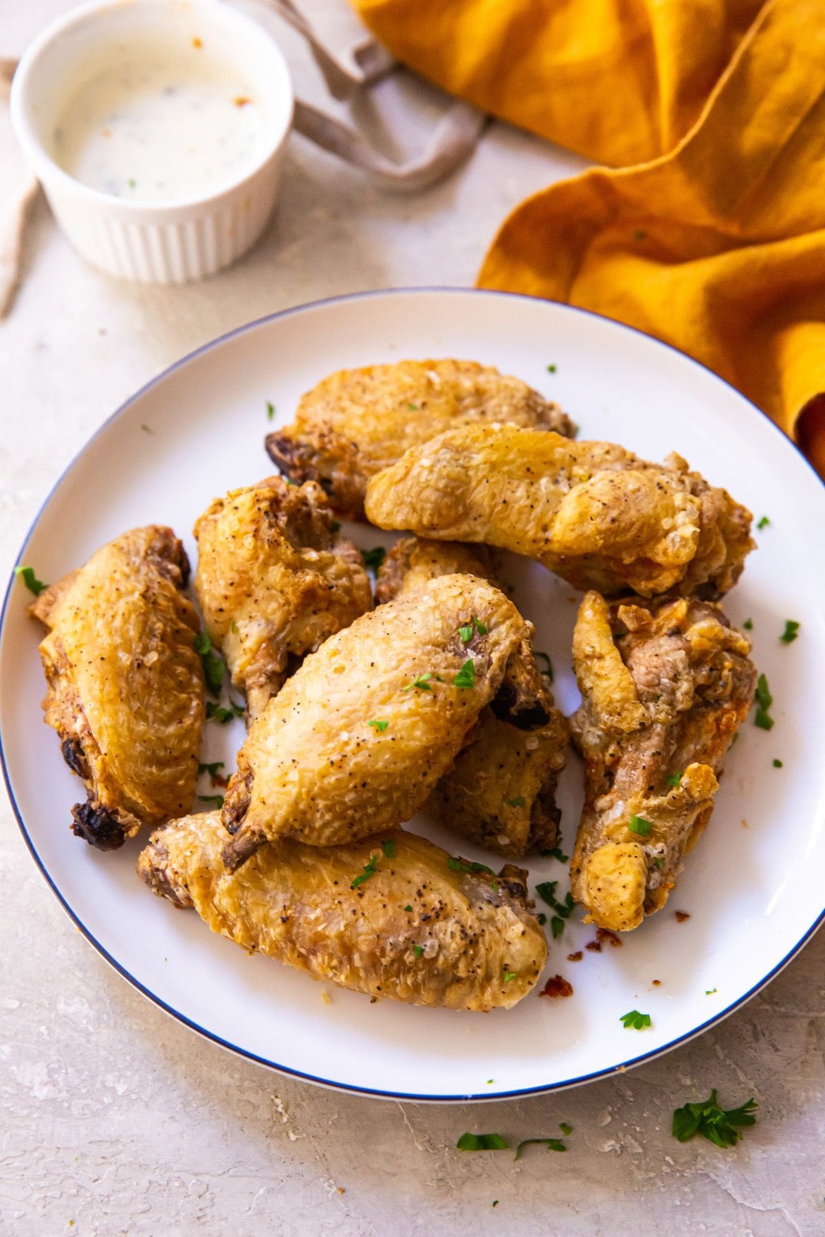 plate of chicken wings ranch and orange napkin in the background