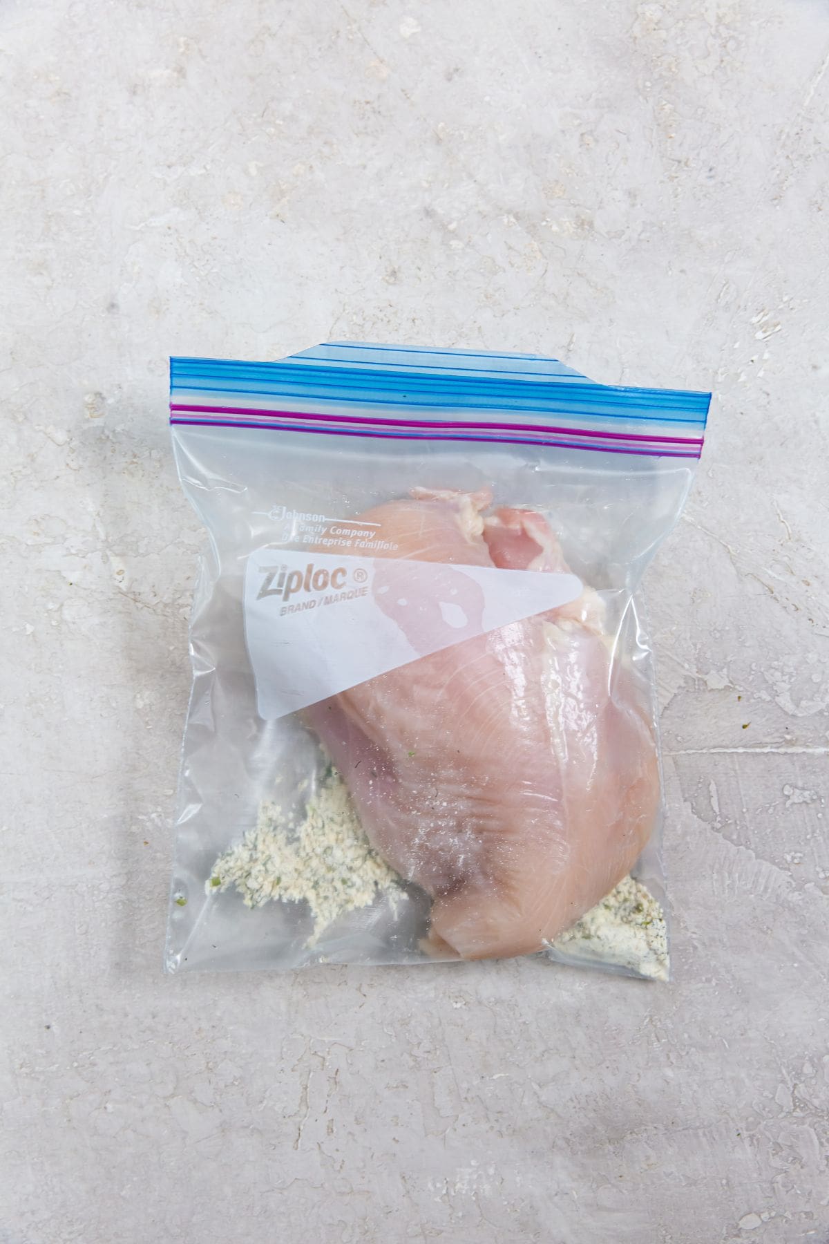 ziplock bag with chicken breast and ranch seasoning inside