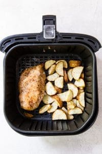 cooked chicken breast and potatoes in an air fryer