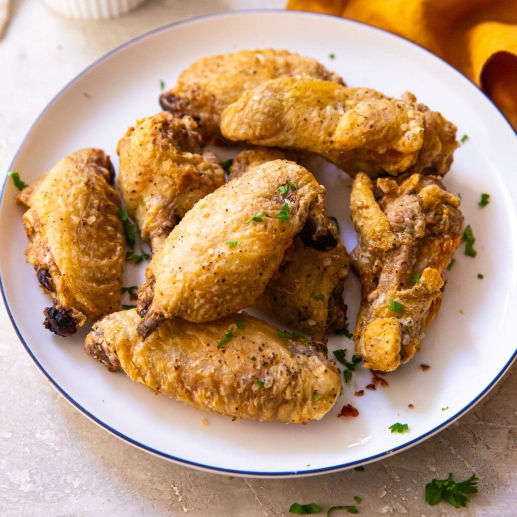 plate of chicken wings orange napkin in the background