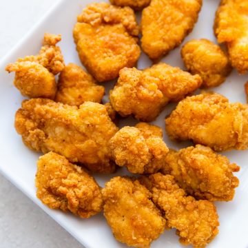 white plate with popcorn chicken on it.