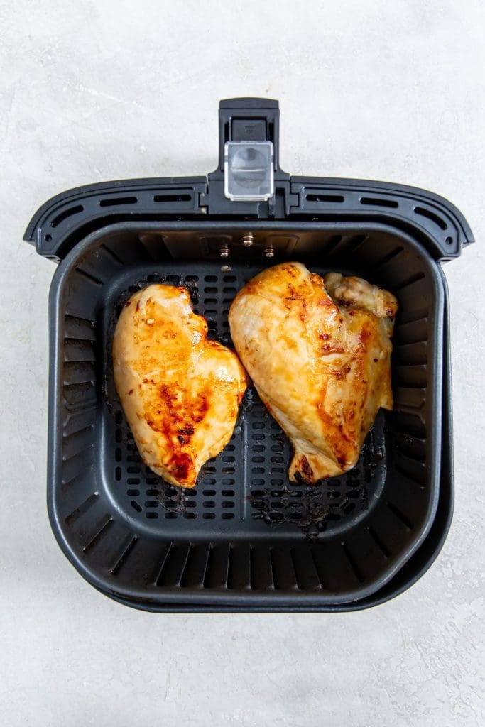 Cooked chicken breast inside a black air fryer