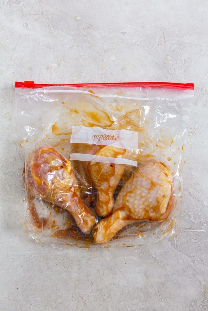 ziplock bag with raw chicken legs and teriyaki sauce inside