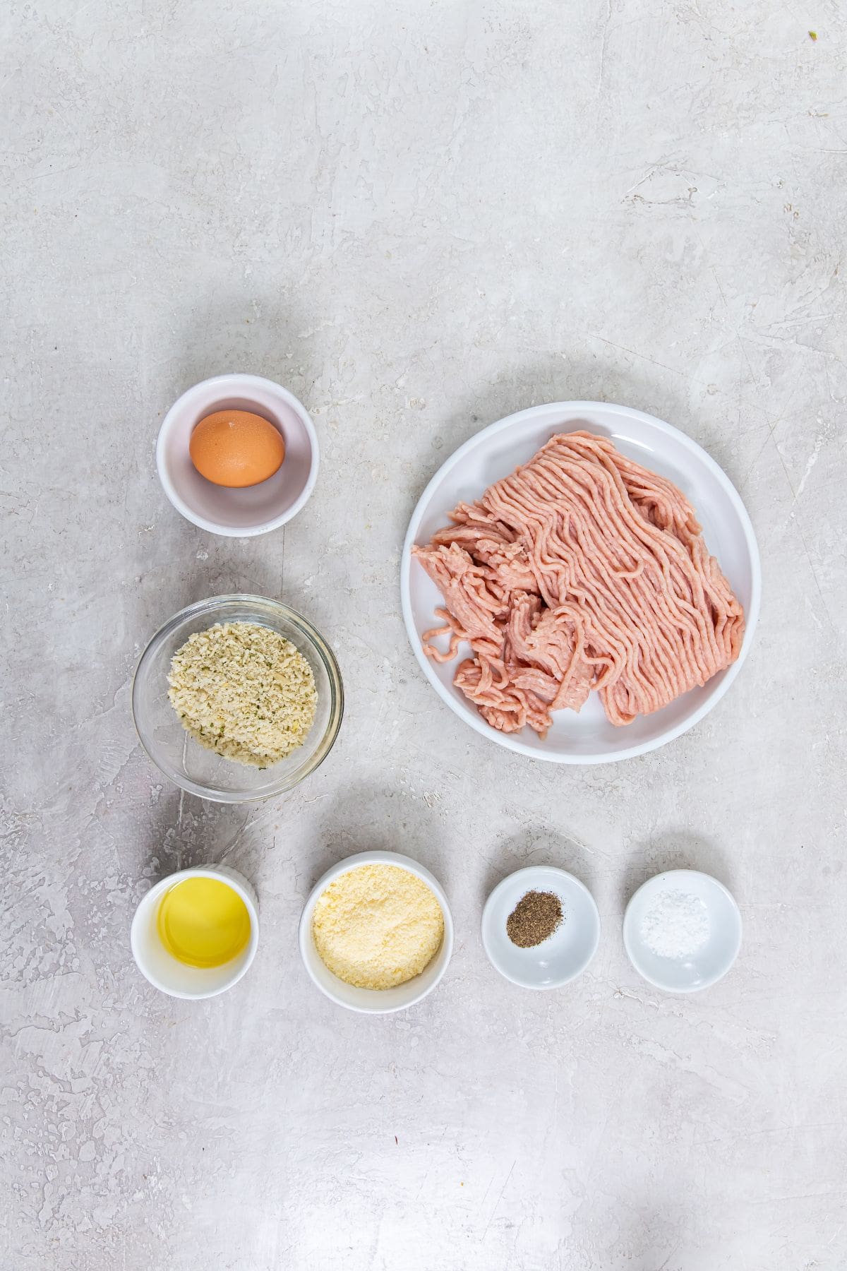 ingredient photo for air fryer chicken meatballs (ground chicken, salt, pepper, Parmesan cheese, panco, avocado oil, and egg)