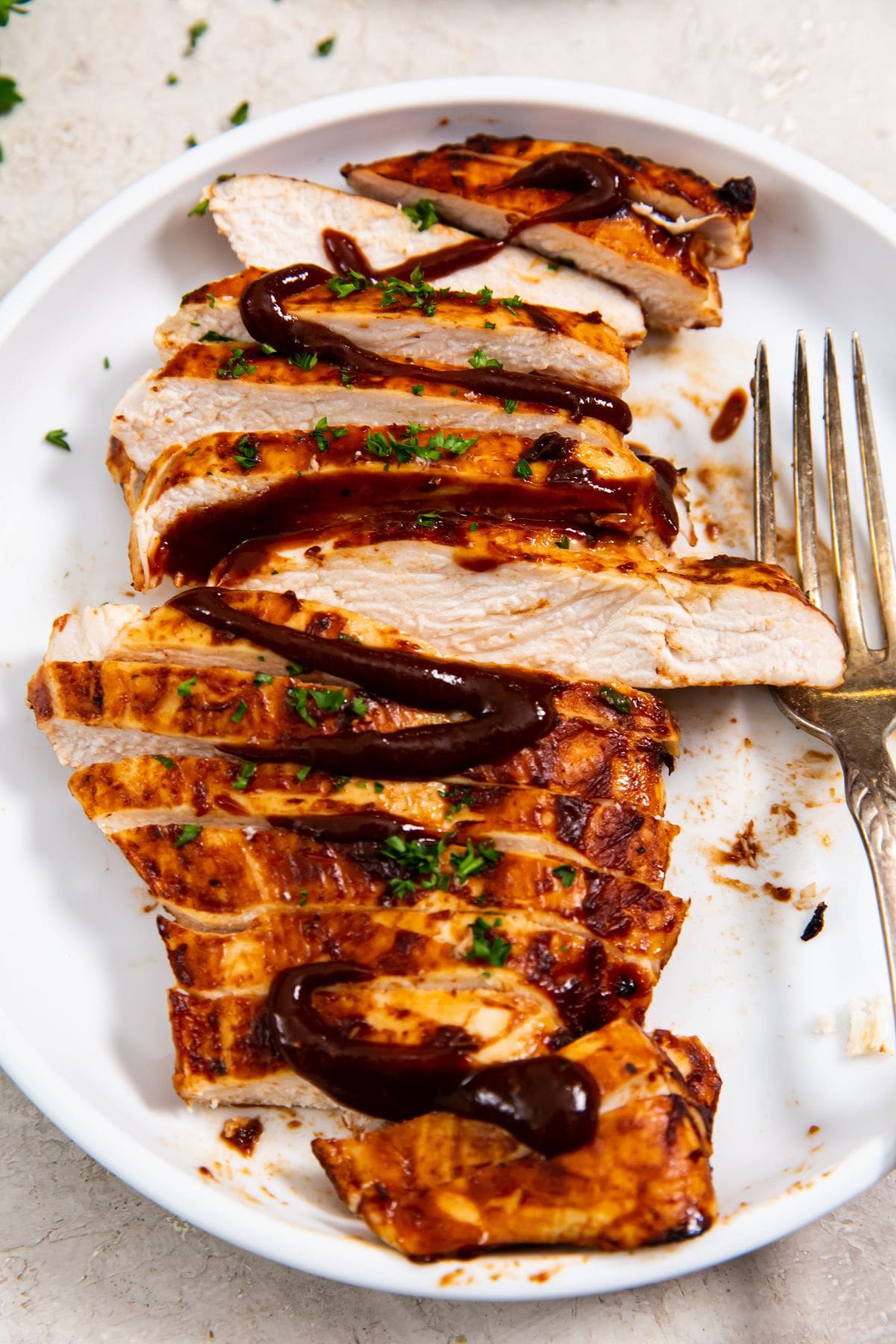 white plate with a chicken cut-up fork on the plate. orange towel