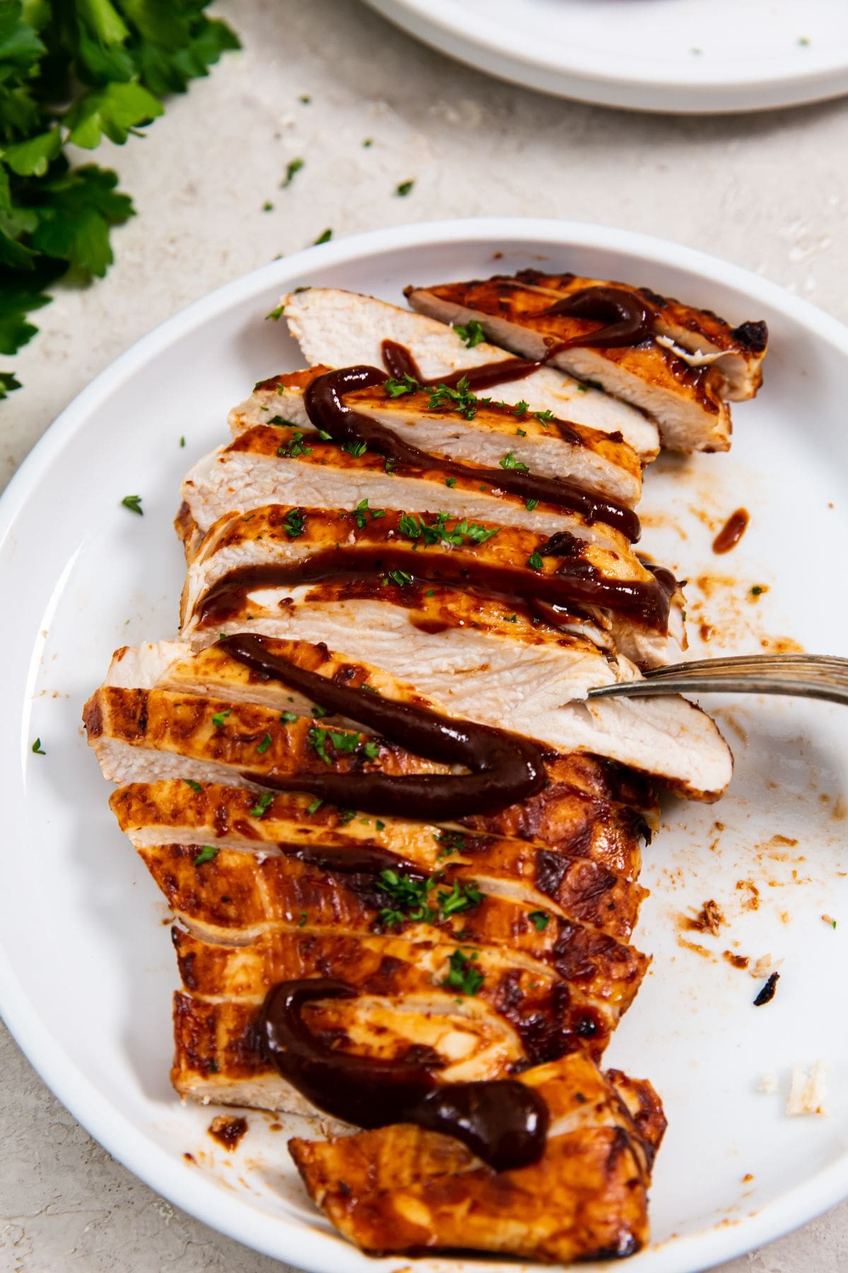 white plate with a chicken cut-up fork on the plate. orange towel