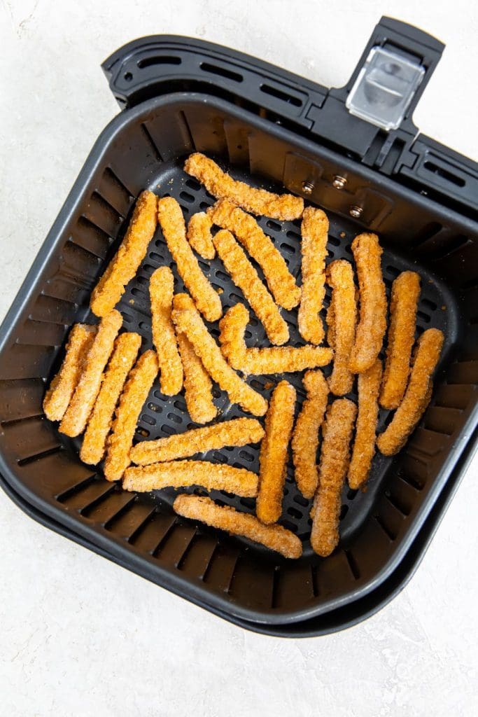 frozen chicken fries inside a black air fryer