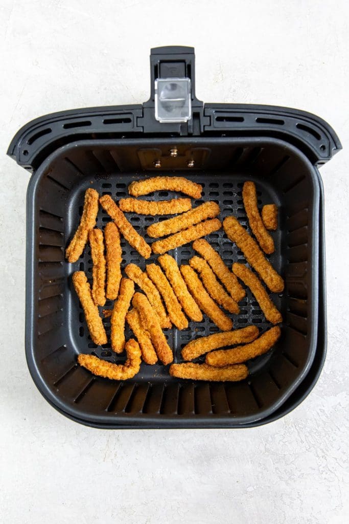 cooked chicken fries inside a black air fryer