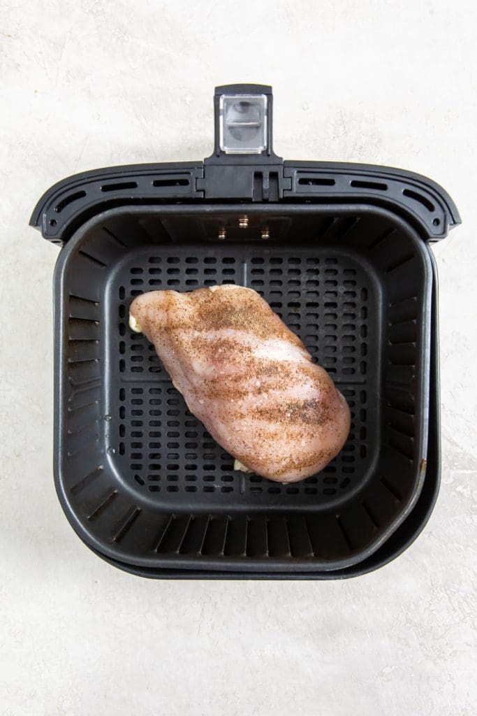 raw chicken inside a black air fryer