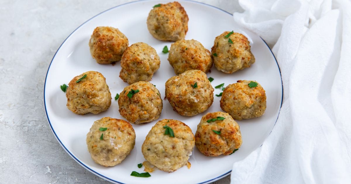 white plate with meatballs on them. white and pink towel next to it.