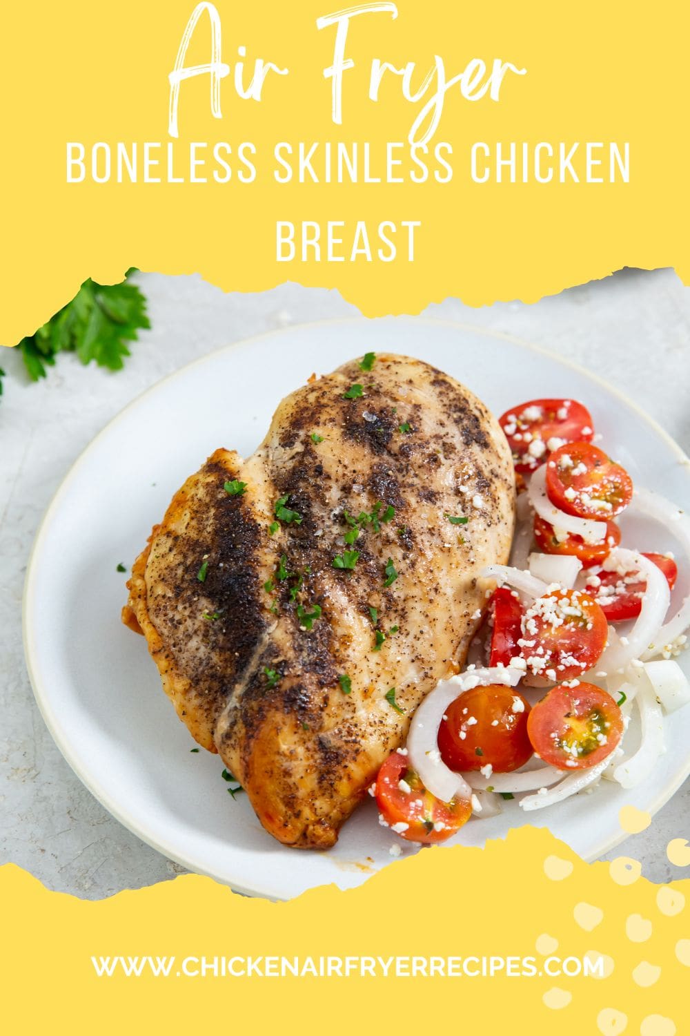 chicken on a plate with tomato salad next to it parsley in the back