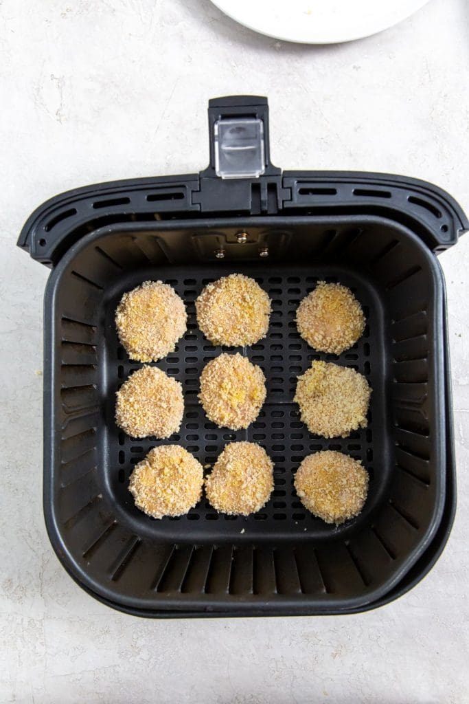 black air fryer with raw chicken inside