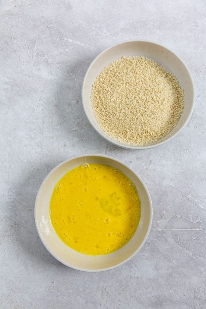 two bowls with bread crumbs and eggs inside