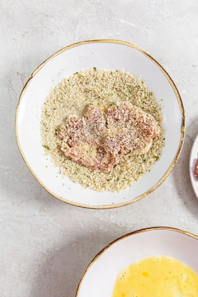 glass bowl with chicken coated in bread crumbs