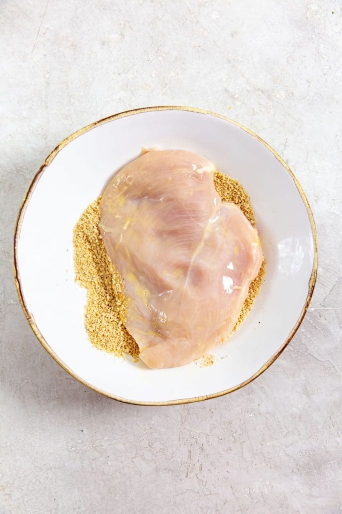 white bowl with seasoning and chicken inside