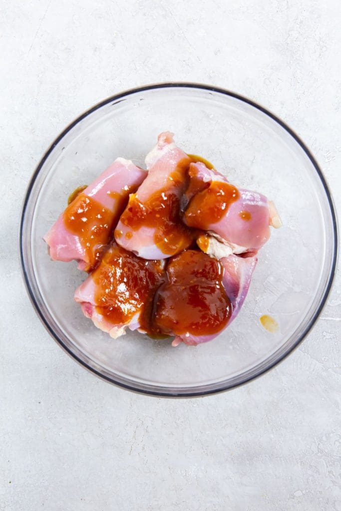 glass bowl with chicken thighs and teriyaki sauce