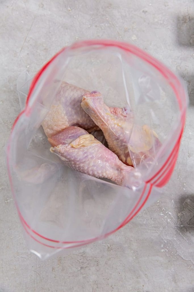 ziplock bag with raw chicken legs inside