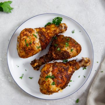 white plate with parsley and gray towel in the back