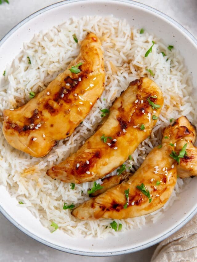 white bowl with chicken and rice parsley and towel in the back