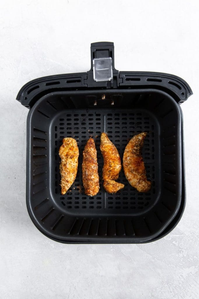 black air fryer with cooked chicken