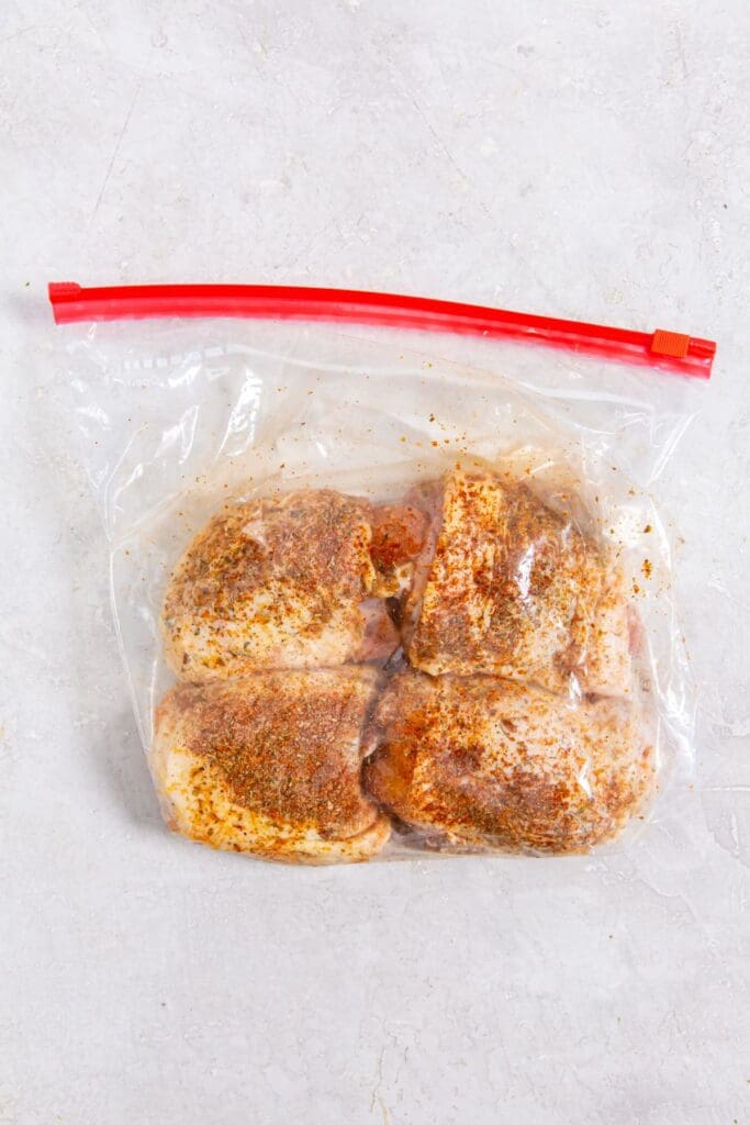 ziplock bag with chicken inside. covered in seasoning