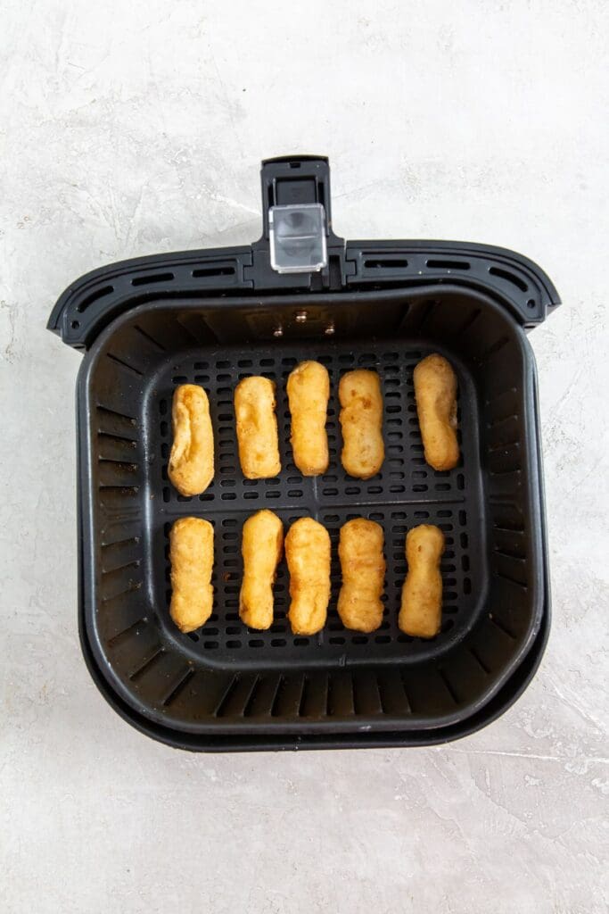 black air fryer with raw chicken inside