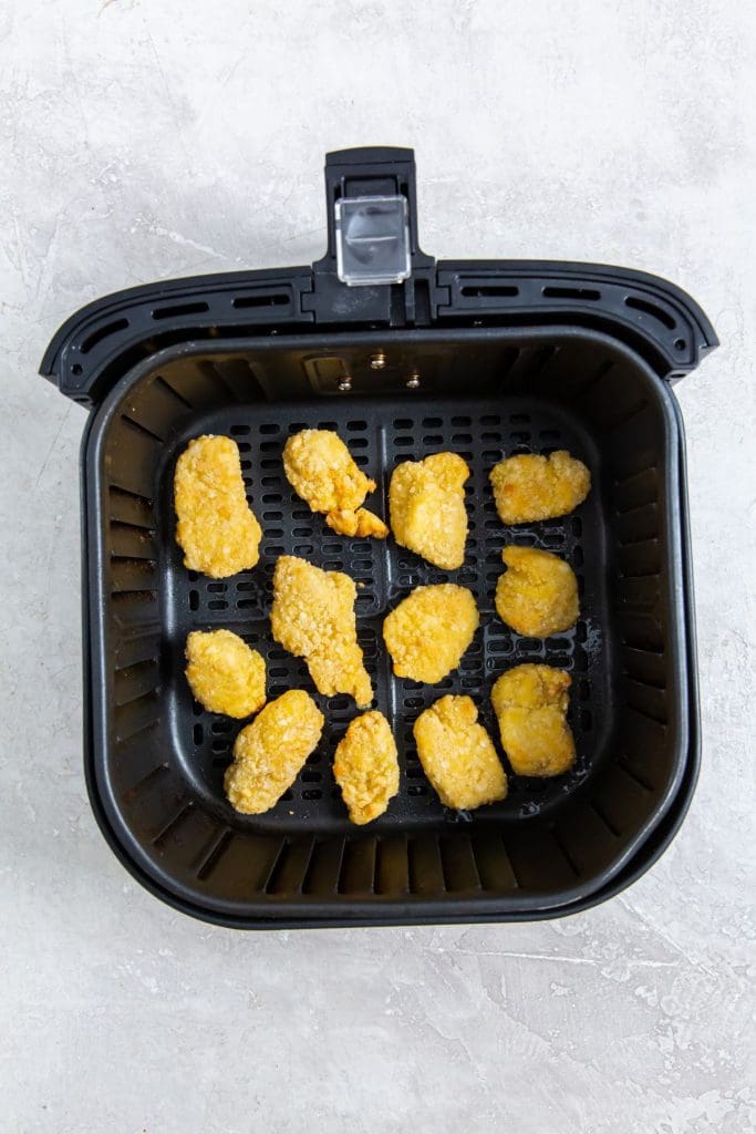 black air fryer with cooked chicken Insidee