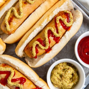 Chicken sausage in hot dog buns. mustard and ketchup on them