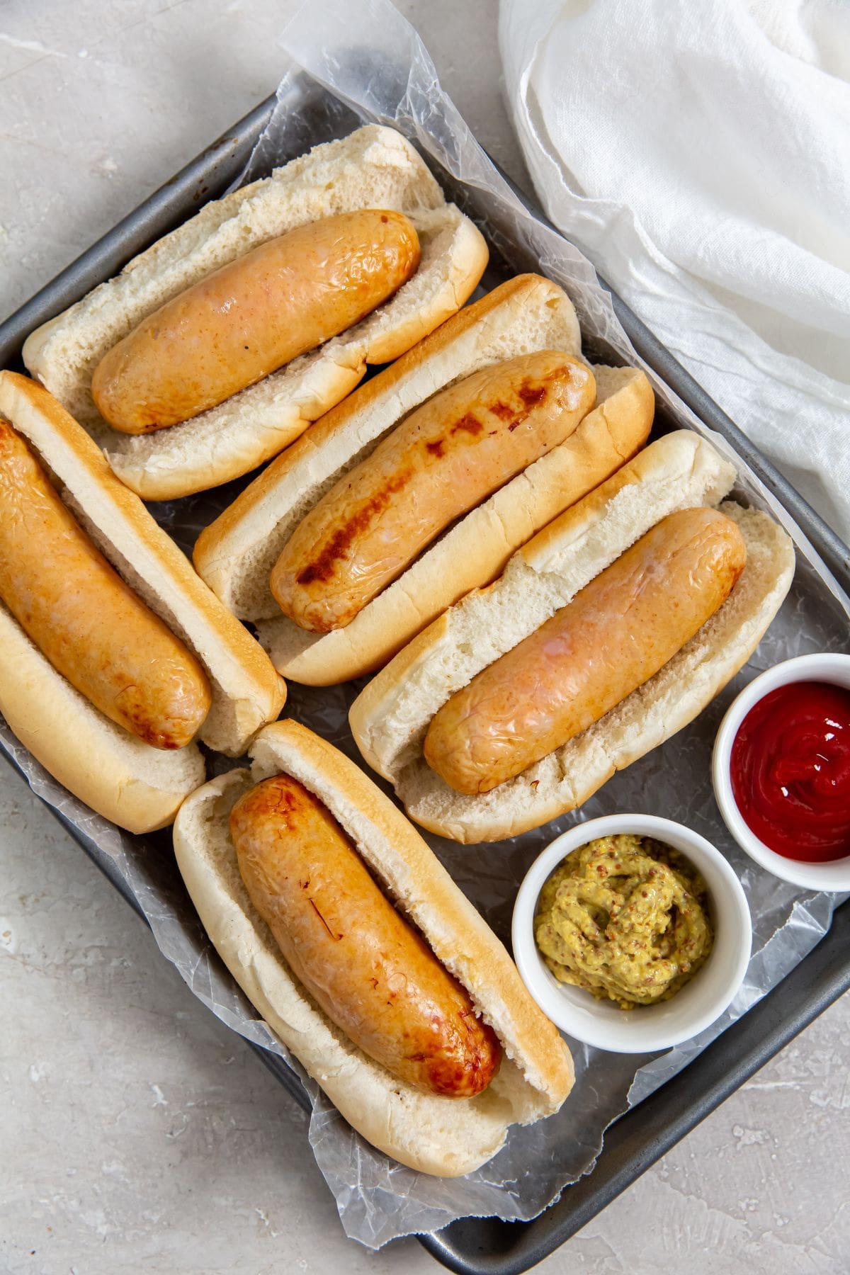 Chicken sausage in hot dog buns. mustard and ketchup on the side