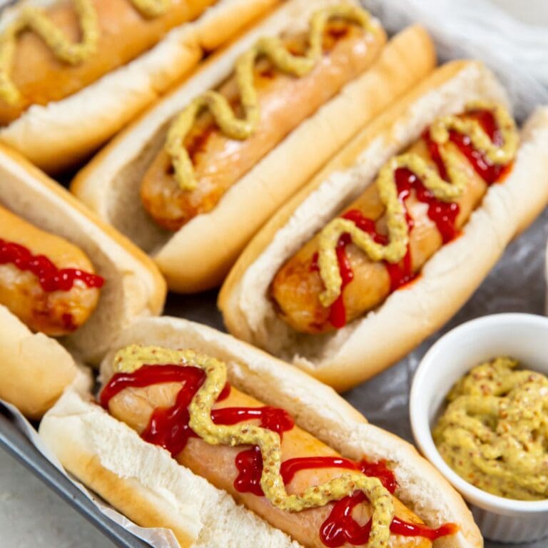 Chicken sausage in hot dog buns. mustard and ketchup on the side