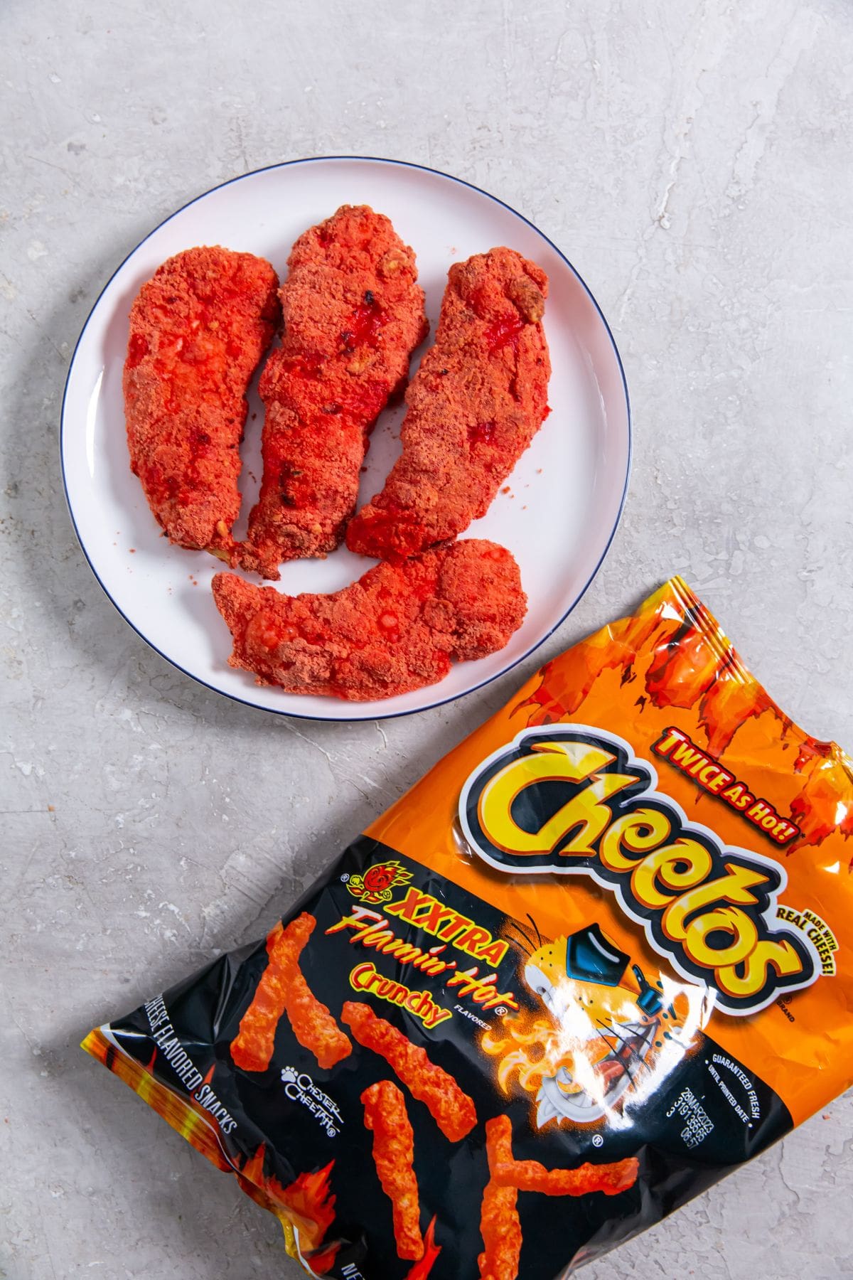 chicken on a plate Cheetos bag next to iy