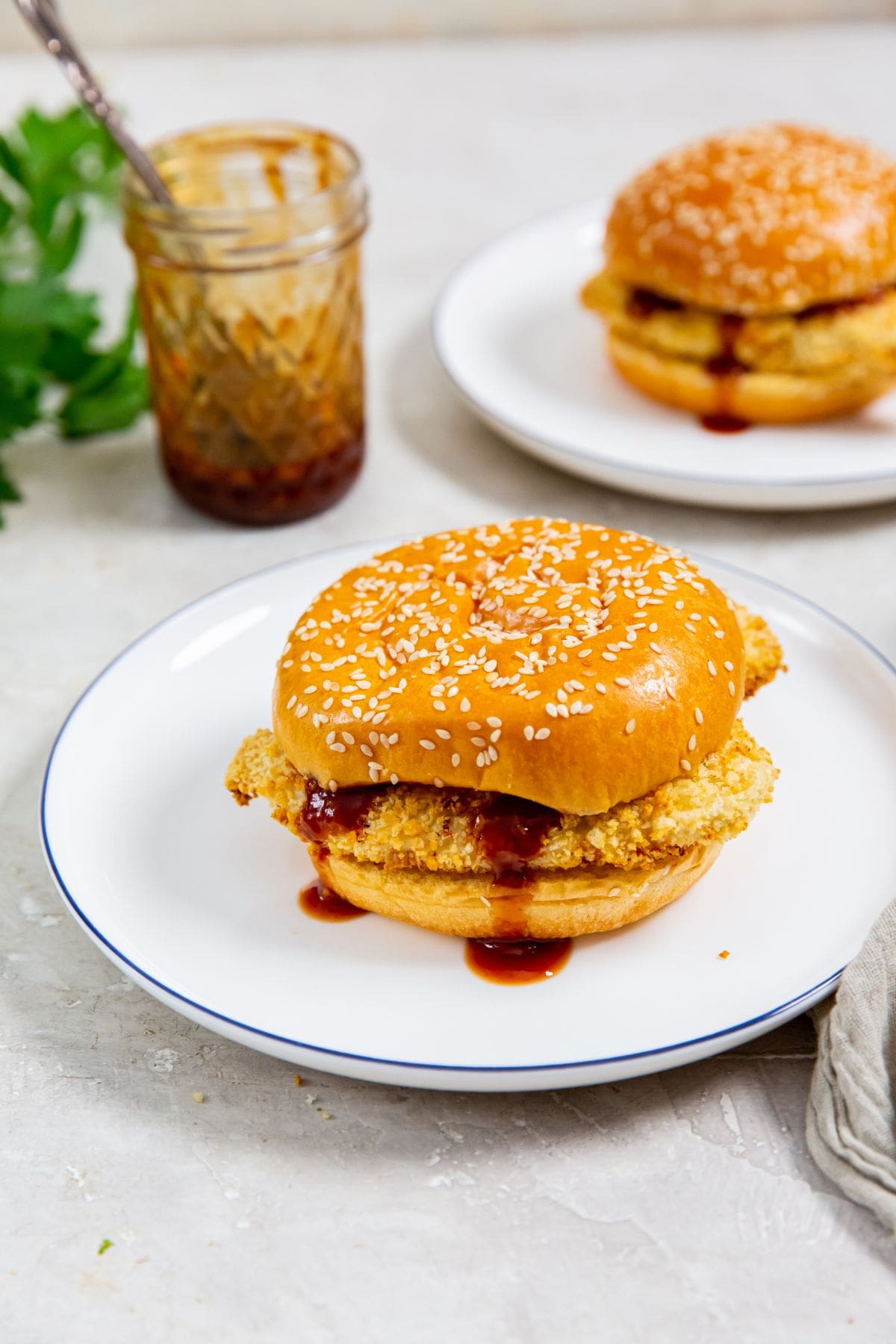 two plates with chicken sandwiches on them