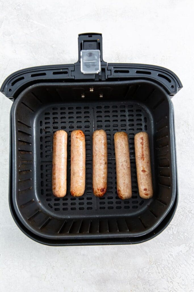 black air fryer basket with cooked chicken inside.