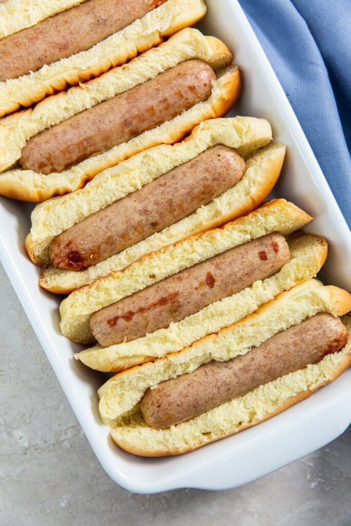 chicken sausage in buns with a blue towel next to it