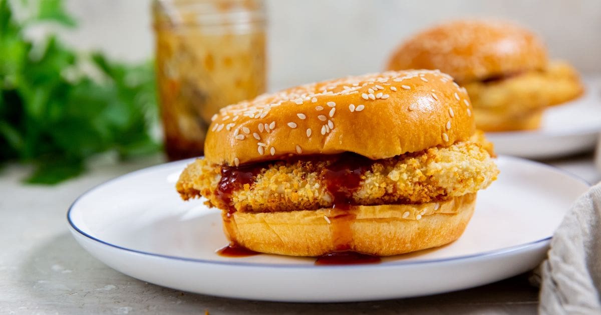 Easy Air Fryer Katsu Chicken Sandwich on a white plate with bbq sauce.