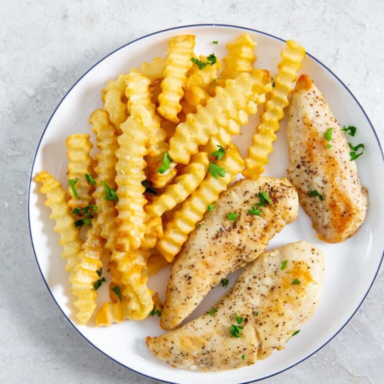 white plate with chicken and fries