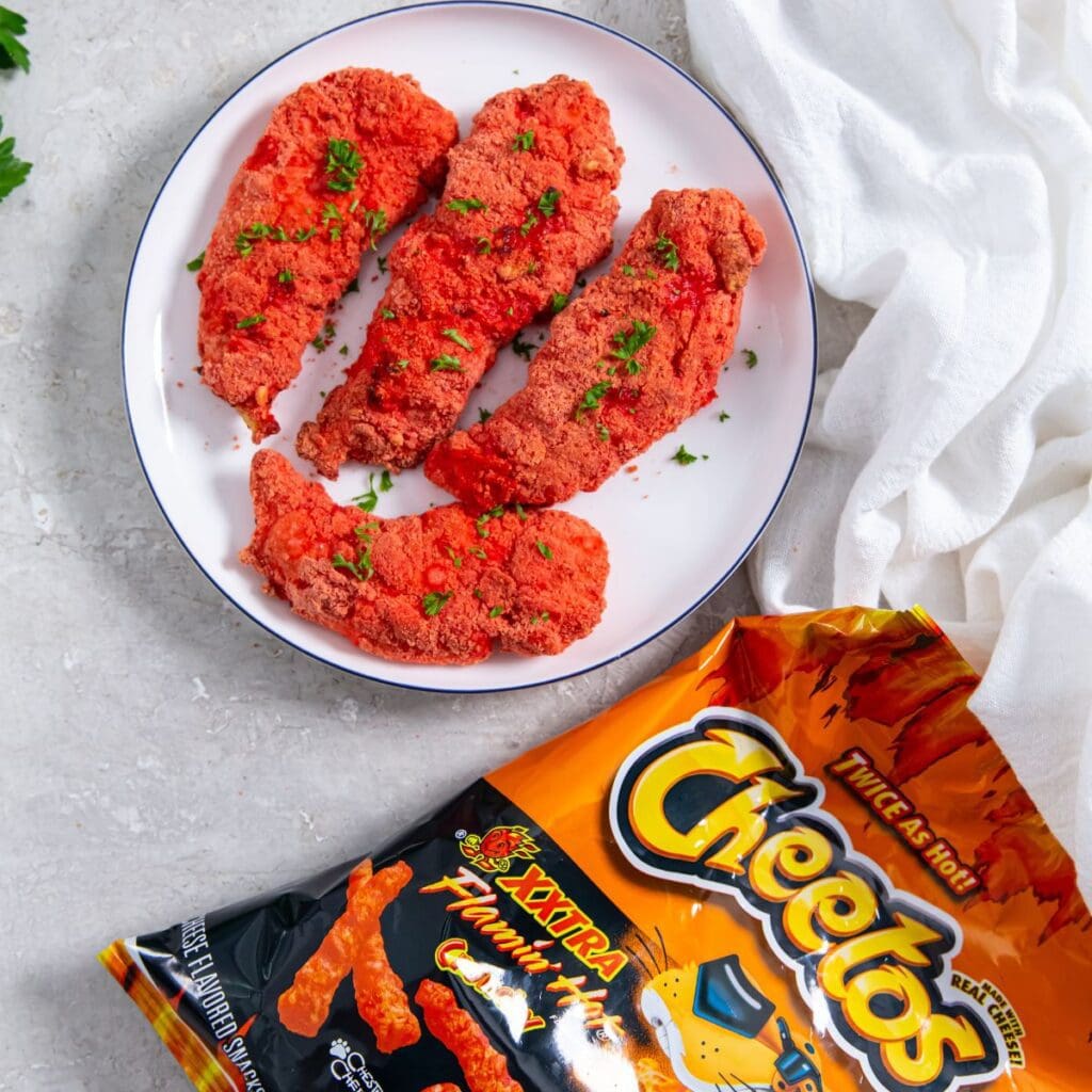 chicken on a plate Cheetos bag next to iy