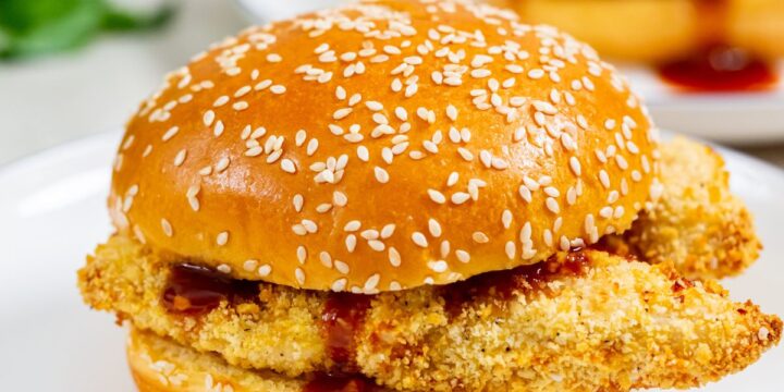 two plates with chicken sandwiches on them