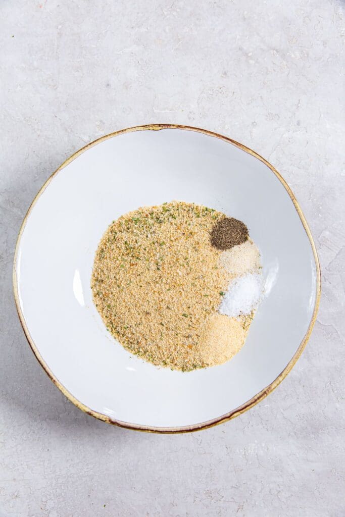 white bowl with breadcrumbs, salt, garlic powder, onion powder, black pepper.