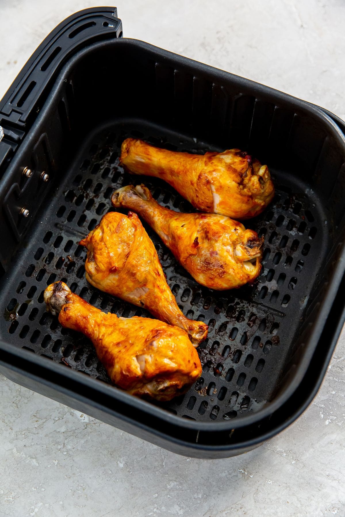 black air fryer basket with chicken inside