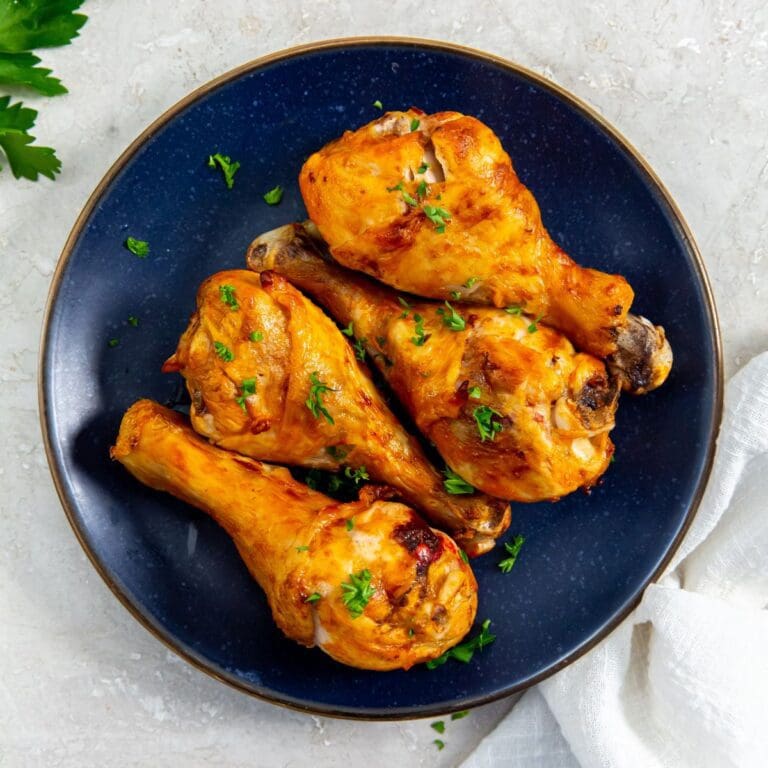 blue plate with chicken on it. parsley and white towel on it