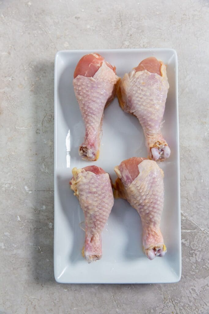 chicken on a white plate with the skin stretched