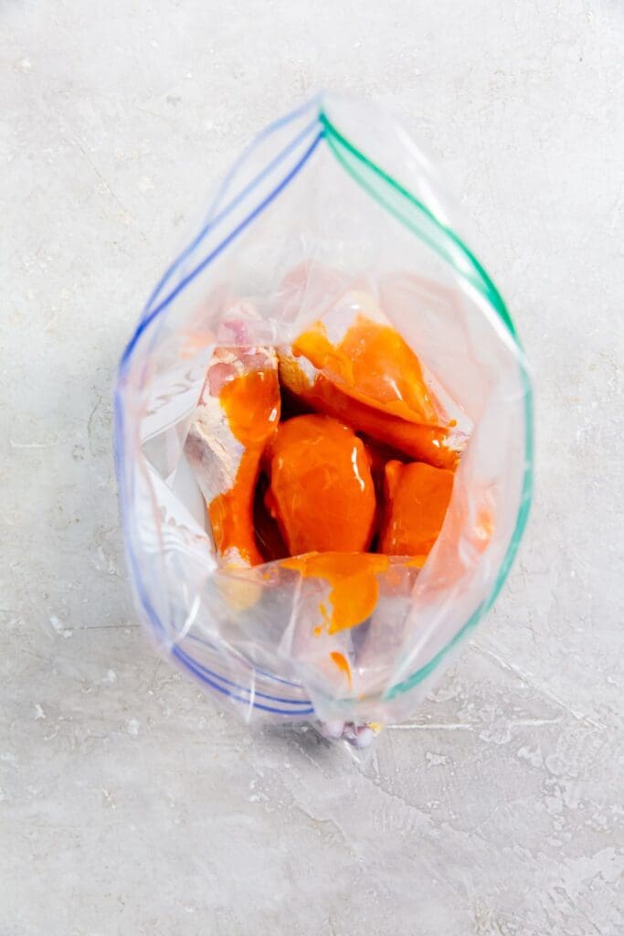 chicken and buffalo sauce inside a ziplock bag