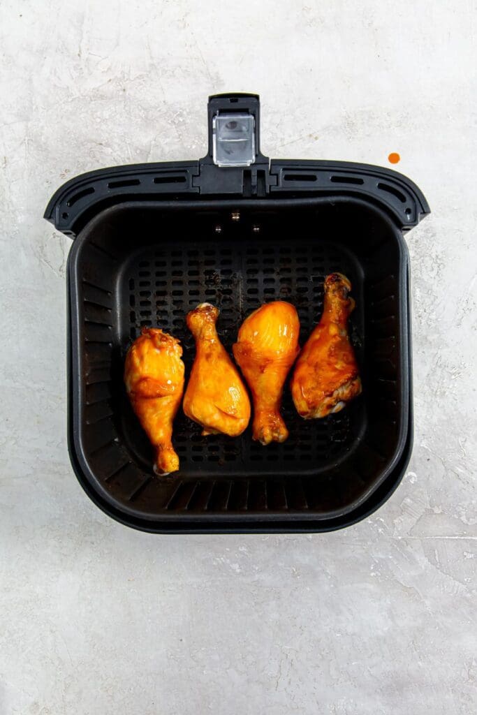 black air fryer basket with chicken inside